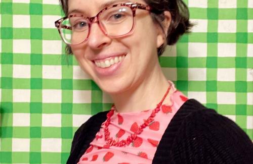 green and white checkered background with smiling artist looking at camera