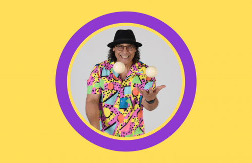 image man with big smile wearing hat and glasses and juggling