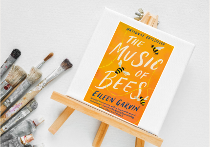 Picture of Tiny art canvas with book jacket of book "Music of the Bees" and paint brushes