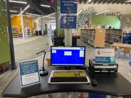 Accessible computer station with assistive tools and adjustable desk zoomed in