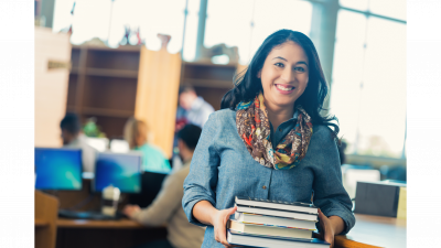 Adult checking out books from library