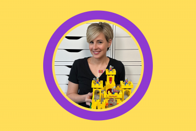 imafe smiling woman holding lego castle build