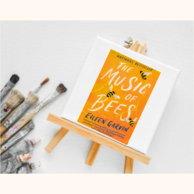 Picture of Tiny art canvas with book jacket of book "Music of the Bees" and paint brushes