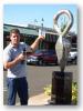 Reporter in front of metal sculpture